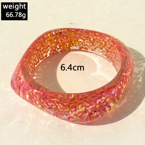 Close-up of pink and orange resin bangle with sparkling sequins weighing 66.78g