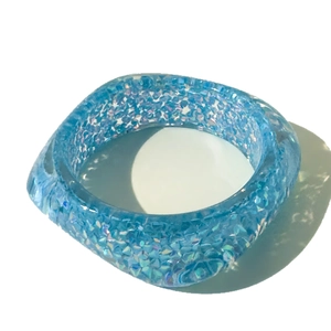 Modern thick translucent blue resin bangle with sparkling glitter and colorful sequins