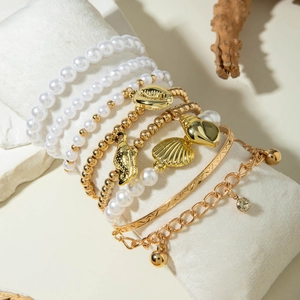 Bohemian gold seashell and pearl multi-layered bracelet set on jewelry display