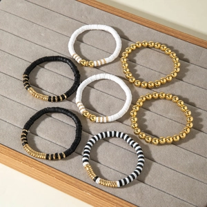 Dettaglio di un set di 7 braccialetti boho con dischi heishi in argilla neri e bianchi