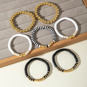 Set di 7 braccialetti elastici boho con perline heishi bianche nere e sfere CCB dorate