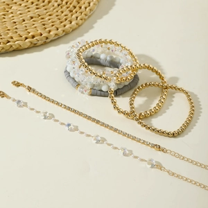 Dettaglio di bracciali bohémien a strati con perline dorate, strass e ciondoli stella