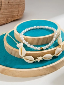 Detalle del set de tobilleras playeras con cuentas blancas, conchas y estrella de mar