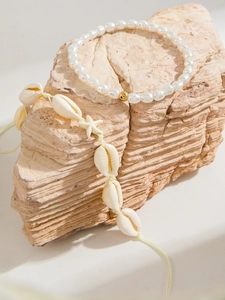 Detalle del conjunto de tobilleras de conchas y estrellas de mar sobre piedra natural