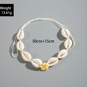 Detalle del collar de conchas de cauri hecho a mano con flor de plumeria y medidas