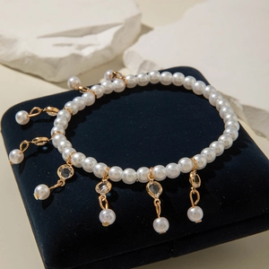 Detalle de pulsera de perlas elegantes con colgantes de circón en caja de terciopelo