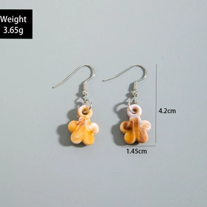 Macro view of shell-inspired acrylic starfish earrings with size dimensions in cm