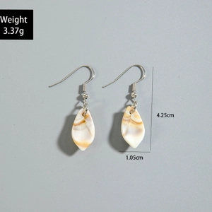 Detail view of leaf-shaped acrylic earrings with marble texture and silver hooks