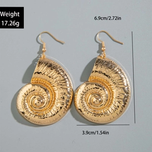 Detailed view of large gold spiral shell earrings showing size and hammered metal texture