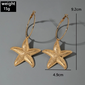 Macro shot of gold starfish hoop earrings showing dimensions and 15g weight measurements
