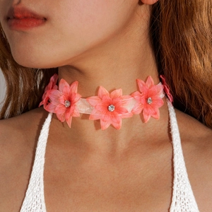 Close-up of pink 3D fabric flower choker with center rhinestone and white silk ribbon