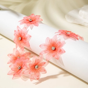 Detailed shot of pink chiffon flower necklace with crystals on white ribbon