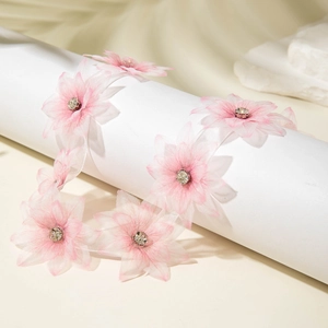 Close-up of pink organza floral ribbon featuring delicate petals with rhinestone centers