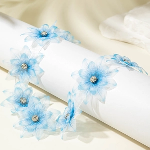 Macro view of light blue gauze flower necklace with sparkling center rhinestones