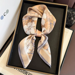 Eleganter Seidenschal in Soft-Orange mit weißen Blumenmustern zur Schleife gebunden