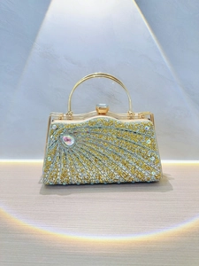Detailed close-up of a luxury gold clutch bag with sparkling rhinestones and sunburst texture