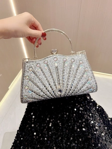 Close-up of a sparkling silver evening clutch with rhinestones and a metal ring handle