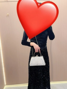 Detail view of rhinestone evening clutch with radiant pearl patterns and metal chain strap