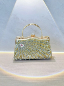 Luxurious evening clutch featuring silver rhinestones and gold handle under stage lighting