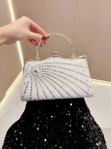 Macro view of crystal buckle and radial rhinestone pattern on the evening handbag