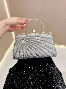Close-up of silver evening clutch featuring sparkling rhinestones and a heart-shaped clasp