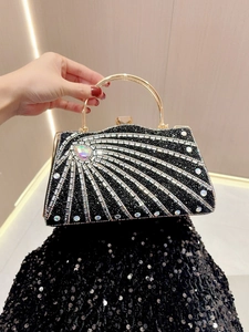 Close-up of black rhinestone evening clutch bag with sparkling patterns and golden handle