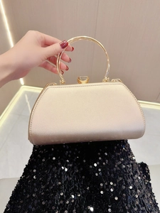 Detail of champagne gold evening clutch with metal ring handle and jewel clasp