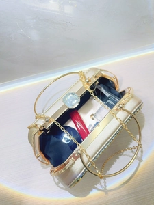 Detailed interior of a gold rhinestone clutch showing capacity for lipstick and perfume