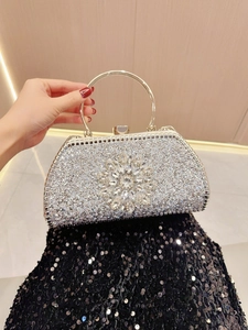 Detailed view of silver sequin evening clutch featuring sparkling crystal sunflower buckle