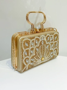Detail of evening clutch featuring intricate pearl beadwork and sparkling rhinestones