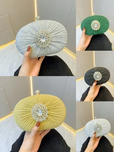 Detailed view of luxury pleated evening clutch bags with sparkling rhinestone floral centers