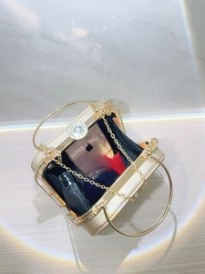 Golden evening bag interior view with diamond clasp, chain, and storage capacity