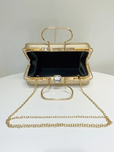 Top view of gold evening bag showing black interior and elegant rhinestone buckle