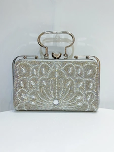 Detail of silver evening bag with inlaid rhinestones and pearl floral patterns