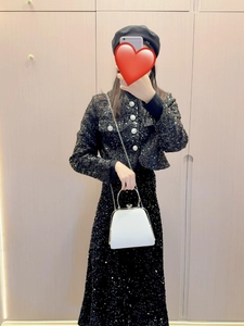 Detail shot of a black sequin suit set with silver buttons and a white metal handle purse