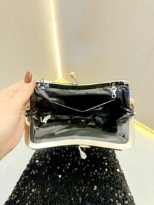 Detail view of the black sequin evening bag interior with satin lining and inner pocket