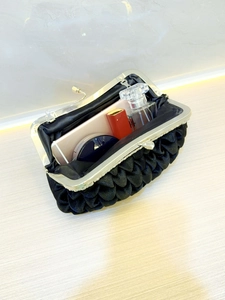 Elegant black pleated satin evening clutch bag with metal frame showing storage capacity