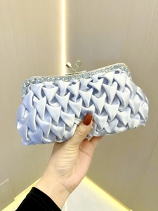 Close-up of light blue pleated satin clutch with sparkling rhinestone border for events