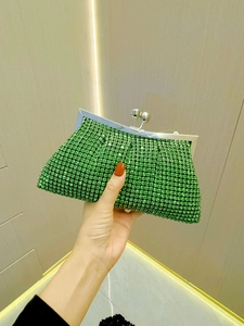 Close-up of luxury emerald green rhinestone evening clutch with spherical metal clasp