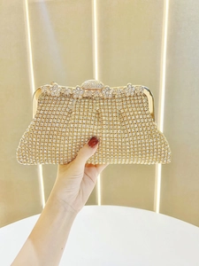 Detail of gold crystal evening clutch featuring sparkling rhinestones and flower clasp