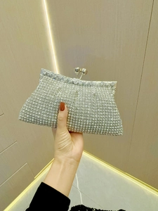 Macro shot of sparkling silver rhinestone dinner clutch with elegant metal ball clasp