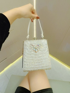 Detailaufnahme der glitzernden Strass-Abendtasche mit Herzmuster und Perlenbesatz