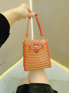 Details der roten Abendtasche mit Strasssteinen, Blumenmuster und Goldperlen