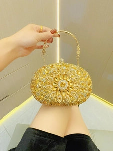 Detail der goldenen Abend-Clutch mit Farbverlauf-Steinen und floralem Edelsteinmuster