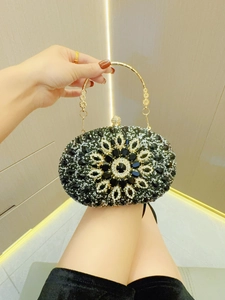 Detailaufnahme der Blumenmuster mit schwarzen und klaren Strasssteinen auf der Abendtasche