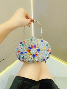 Detailansicht der silbernen Clutch mit bunten Kristallblumen und Metallgriff