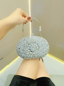 Detailaufnahme der silbernen Abendtasche mit funkelndem Blumenmuster aus Strasssteinen