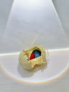 Interior detail of golden sphere evening bag with rhinestones, showing chain and lining
