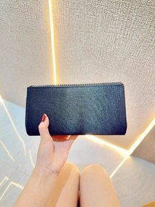 Close-up of black glitter clutch bag with shimmering finish and sleek rectangular design