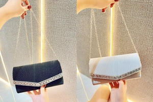 Detail of pleated evening clutch bags in black and white with sparkling crystal trim